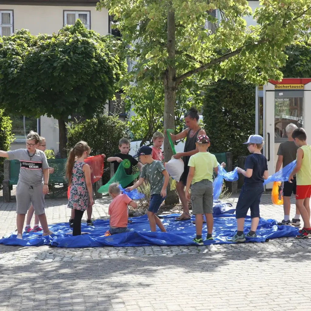 Dzieci i dorośli poczas warsztatu na dworze