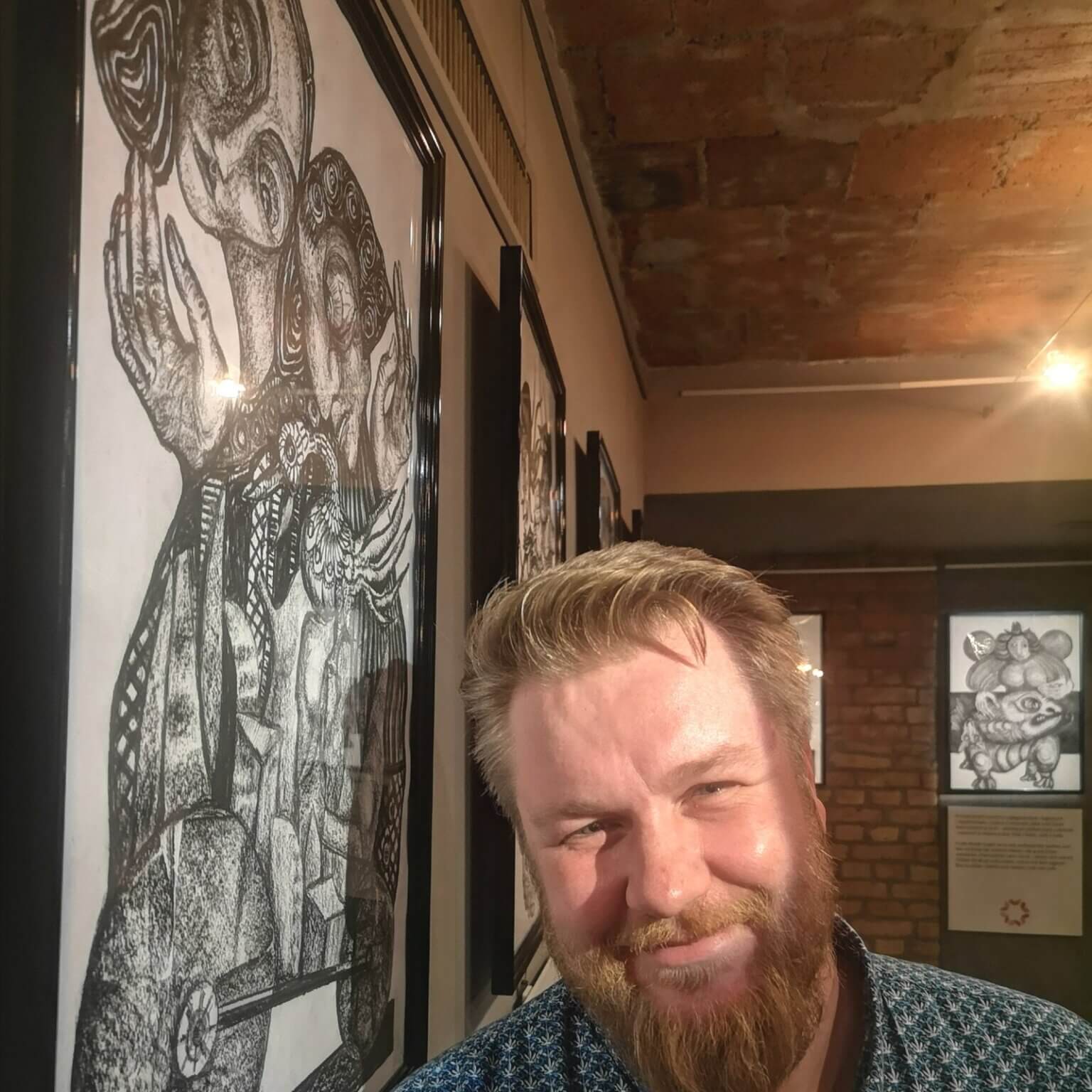 Michał Gierke na tle prac na otwarciu wystawy w Galerii Kapitańskiej w Szczecinie