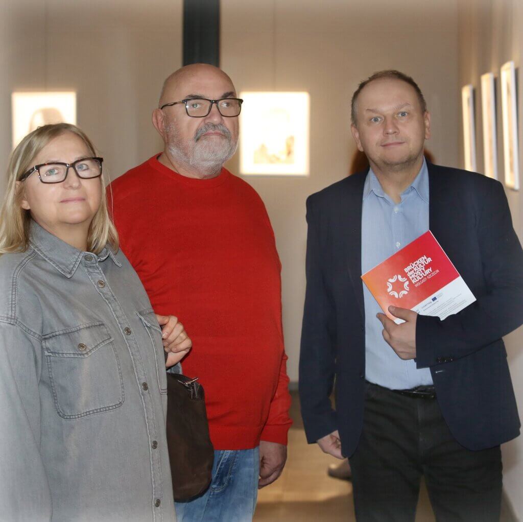 Goście otwarcia wystawy Anety Goludy w Szczecinie, jeden z nich trzyma folder projektu